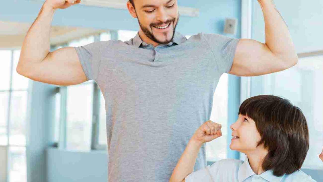 healthy-father-and-son-showing-their-biceps-to-each-other-and-smiling