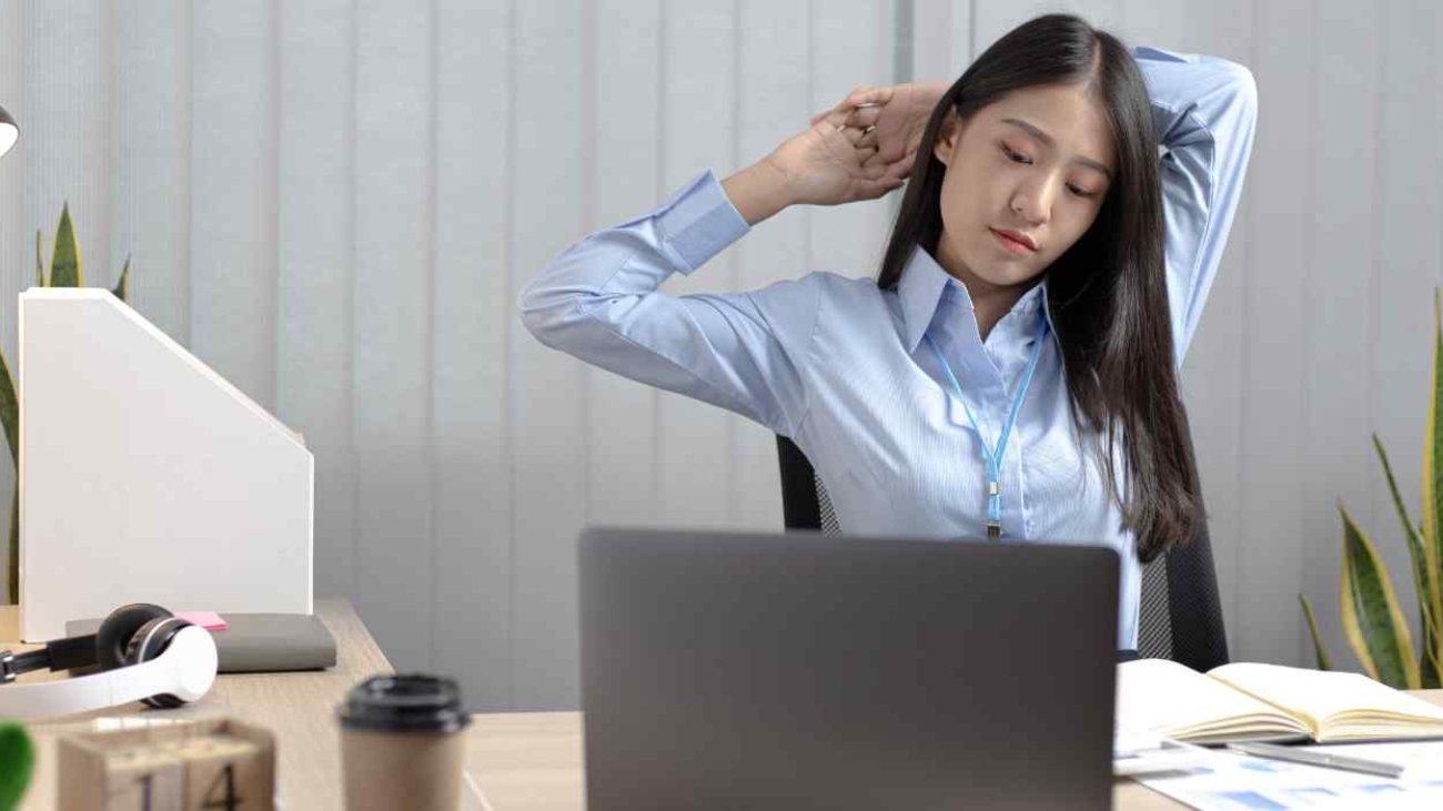 tired-employee-stretching-in-her-office-desk