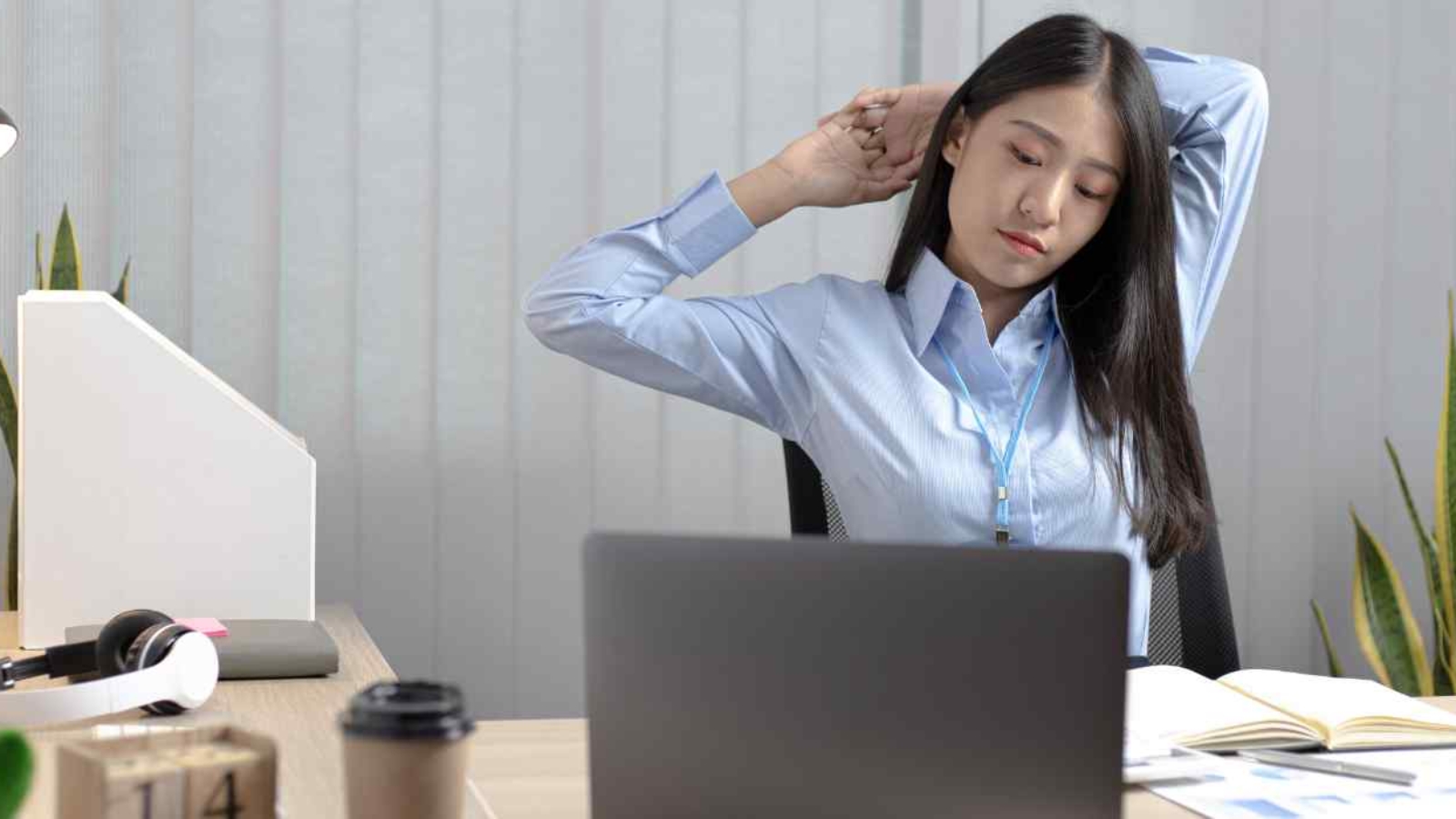 tired-employee-stretching-in-her-office-desk